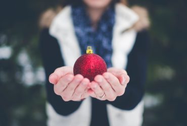 Frau hält Christbaumkugel