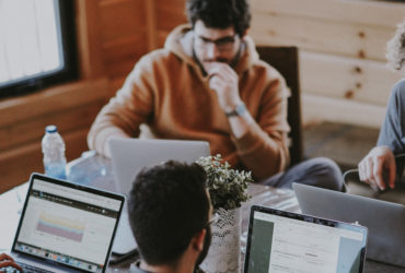 Männer arbeiten an Laptops