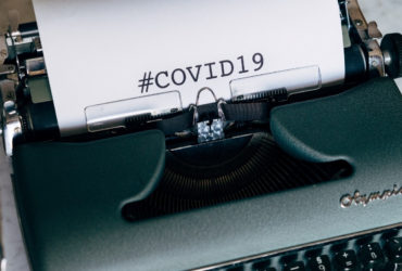 Schreibmaschine mit Blatt und Schriftzug COVID19