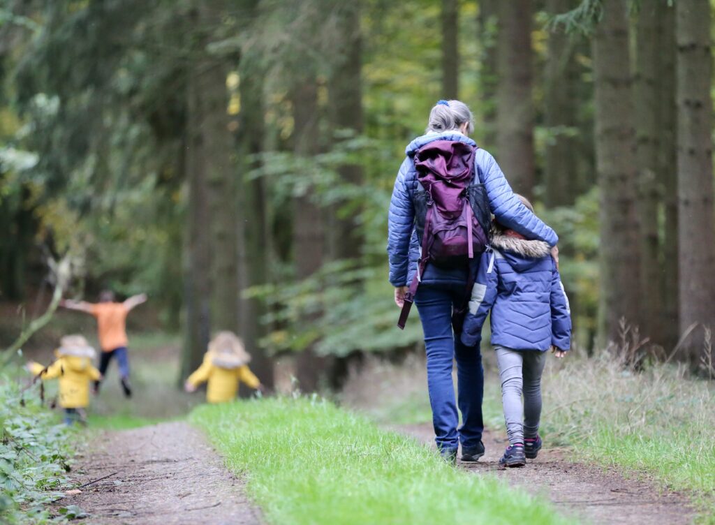 Frau und Mädchen wandern durch den Wald